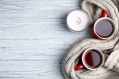 Photo of Flat lay composition with cups of hot tea on light wooden background, space for text. Winter drink