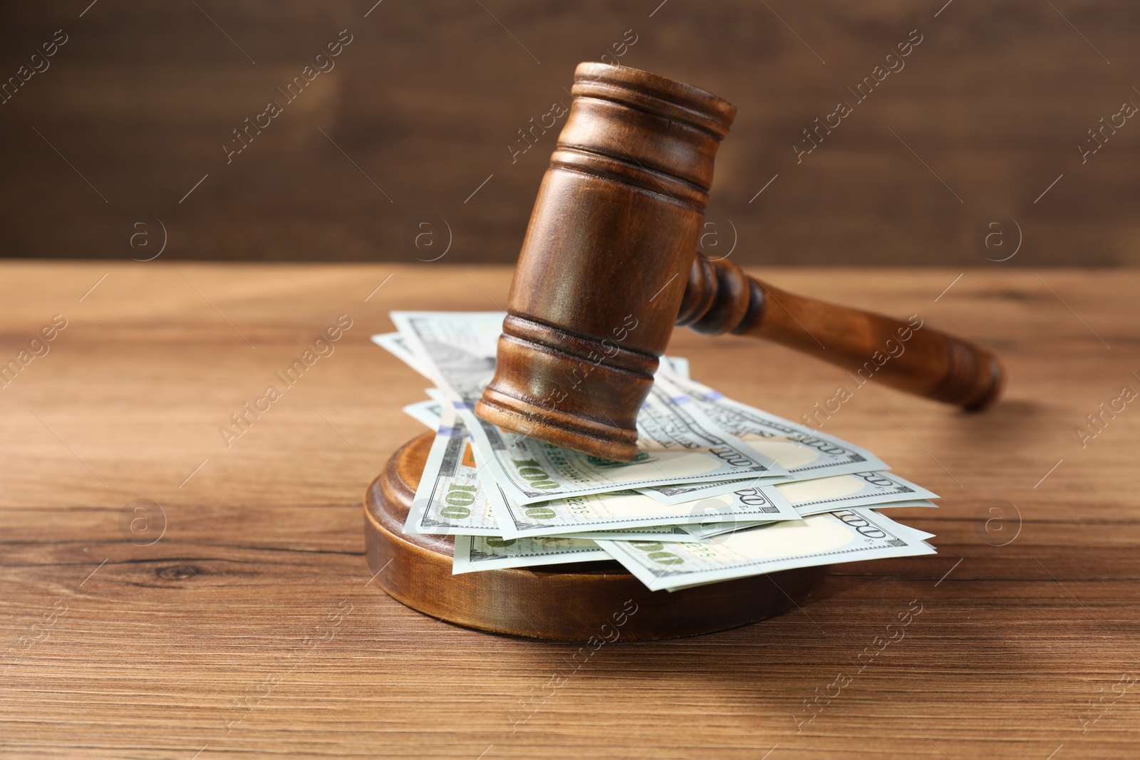 Photo of Judge's gavel and money on wooden table. Space for text