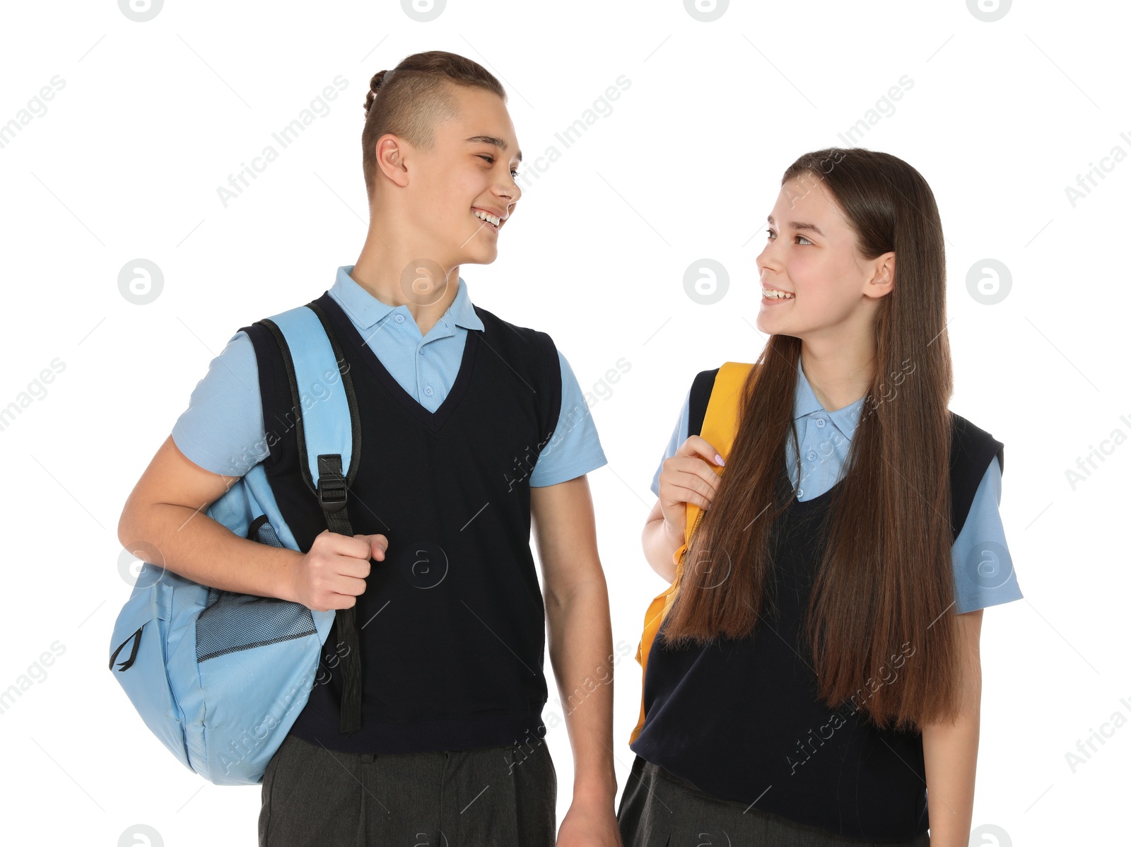 Photo of Portrait of teenagers in school uniform with backpacks on white background