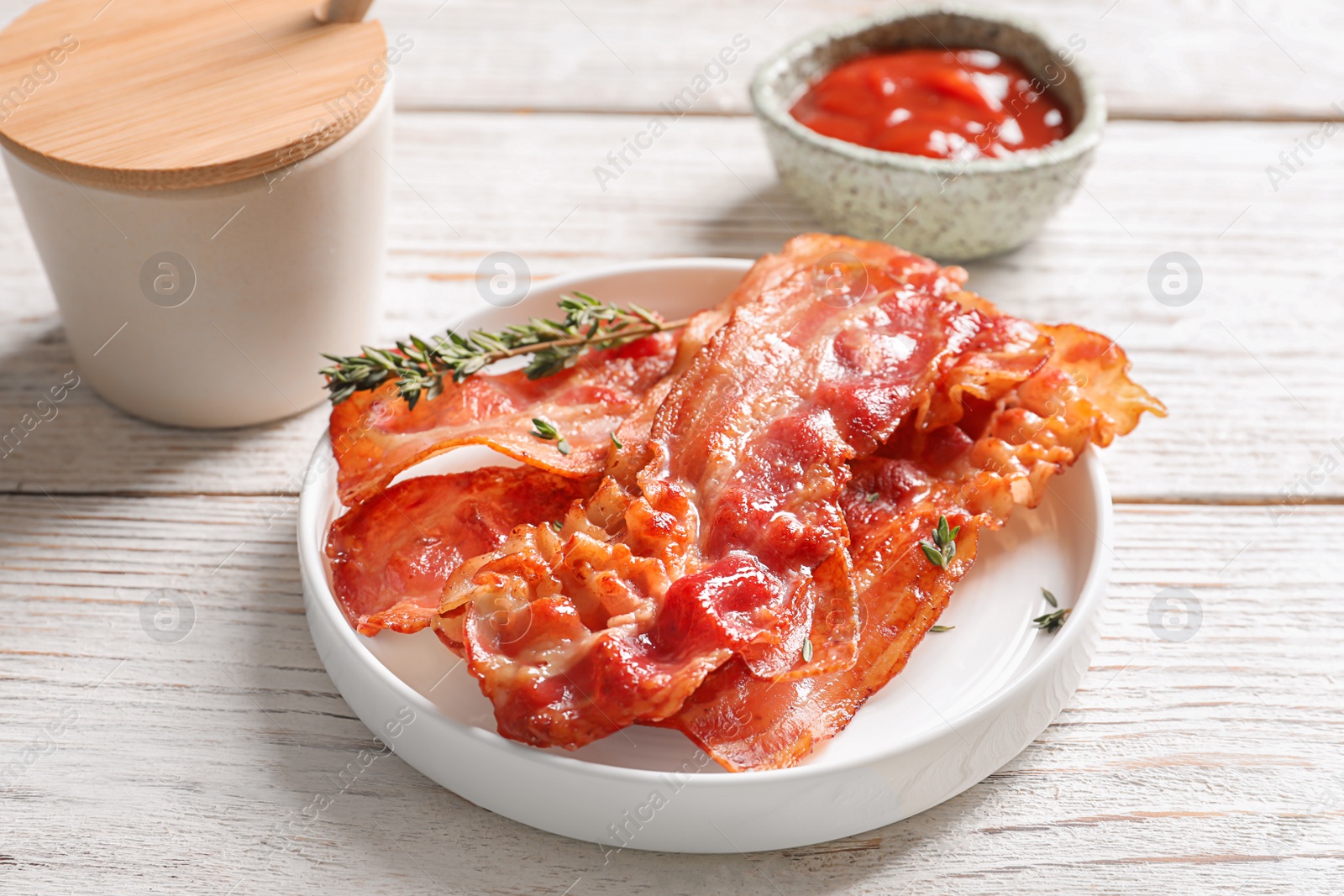 Photo of Plate with fried bacon on table