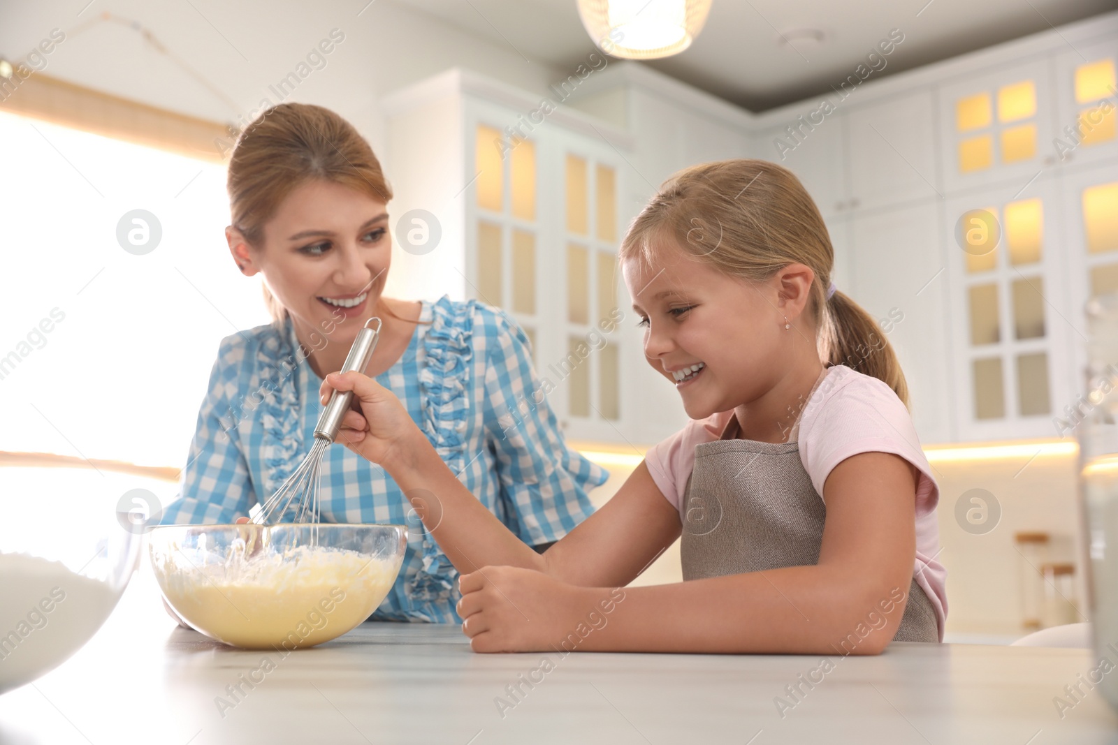 Photo of Mother and daughter making dough together in kitchen