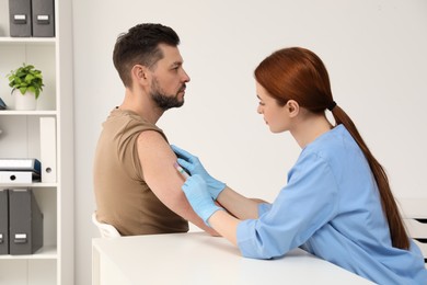 Photo of Doctor giving hepatitis vaccine to patient in clinic