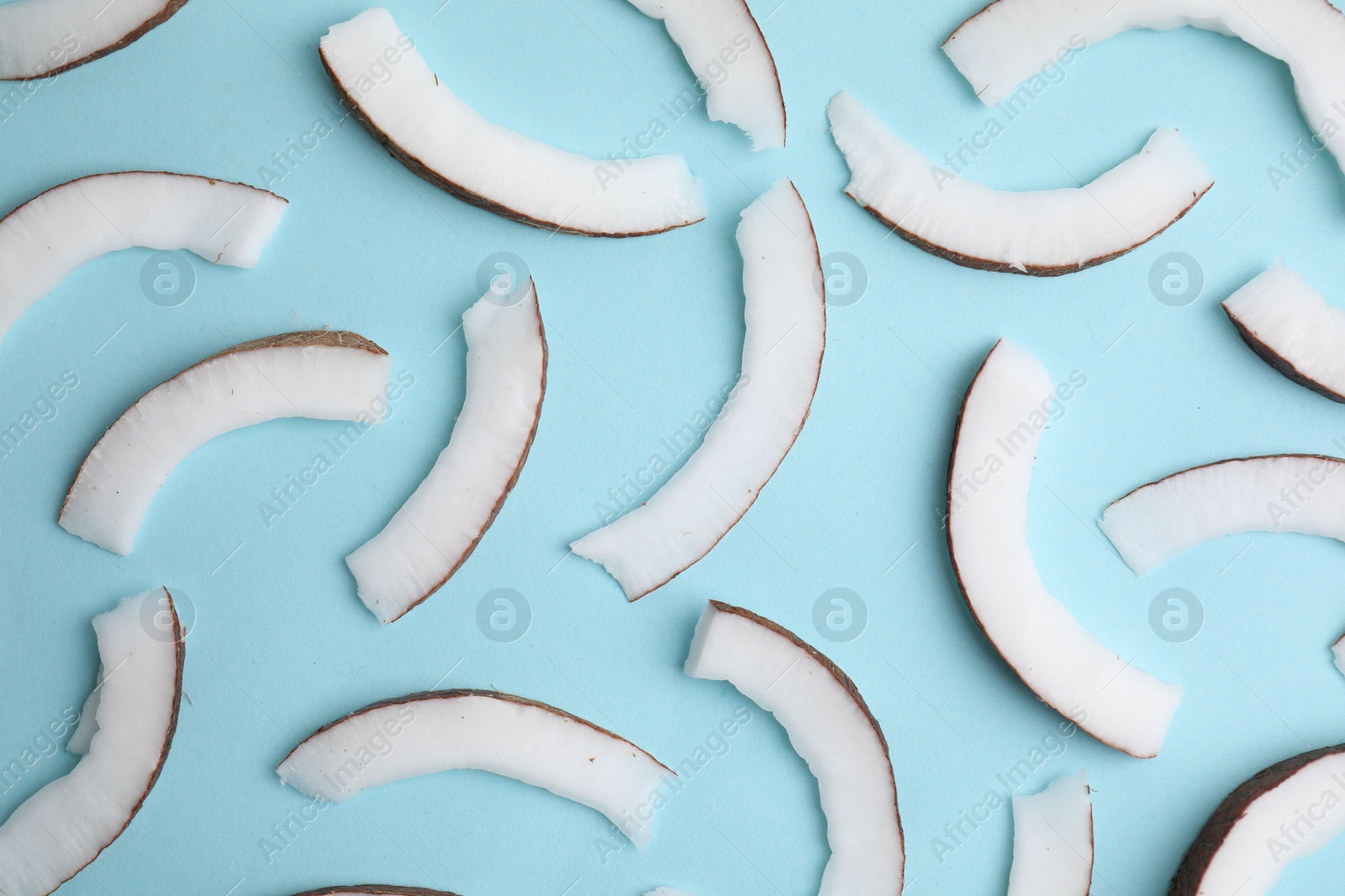Photo of Fresh coconut pieces on light blue background, top view