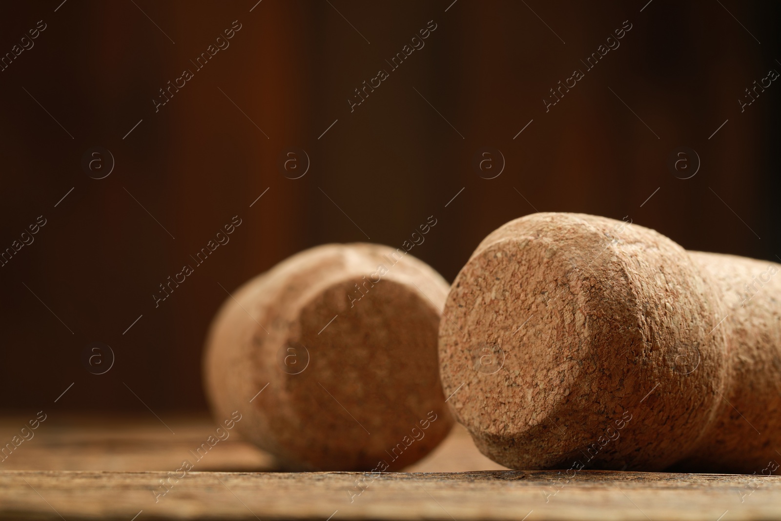 Photo of Corks of wine bottles on wooden table, closeup. Space for text