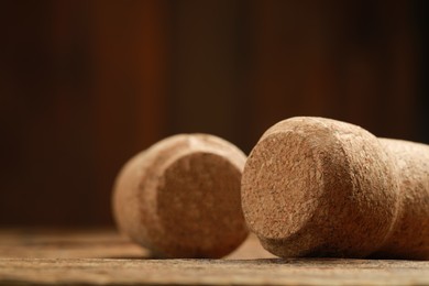 Corks of wine bottles on wooden table, closeup. Space for text