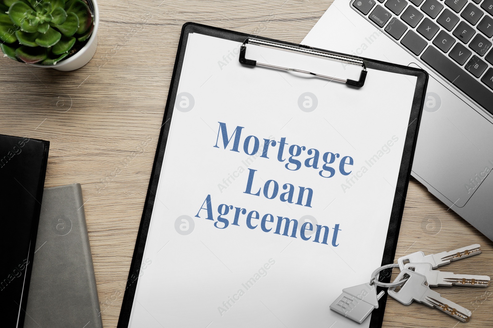 Image of Mortgage loan agreement, house keys and laptop on wooden table, flat lay