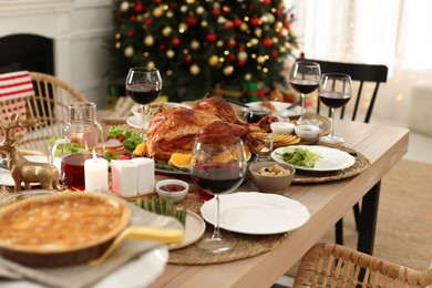Photo of Festive dinner with delicious baked turkey served on table indoors. Christmas celebration
