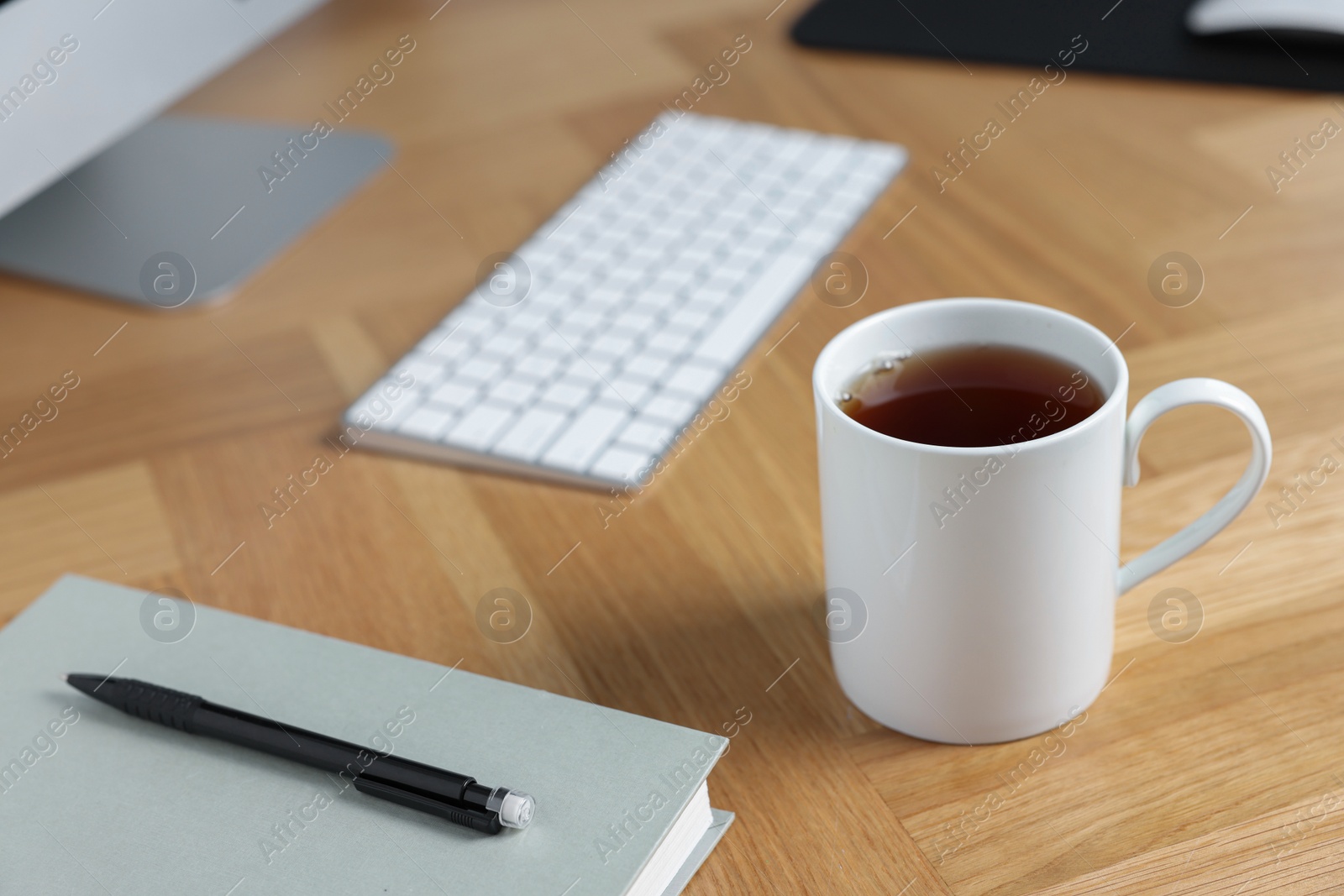 Photo of Ceramic mug of tea on wooden table. Mockup for design