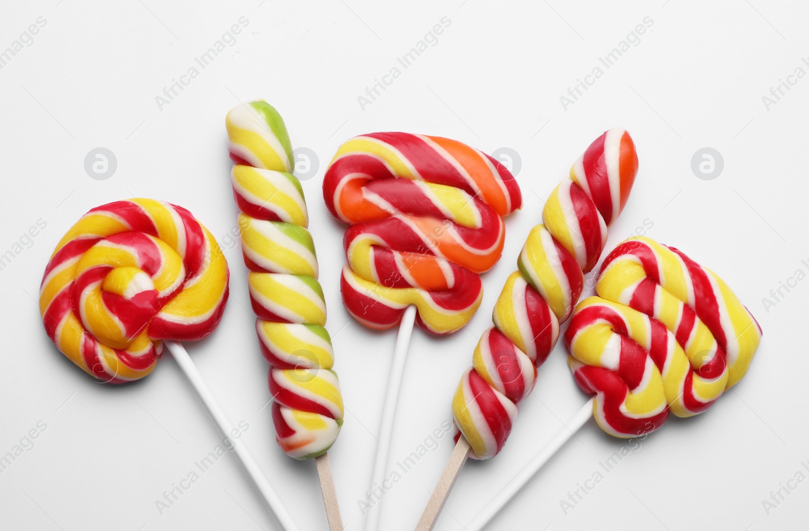 Photo of Sweet lollipops on light background, flat lay