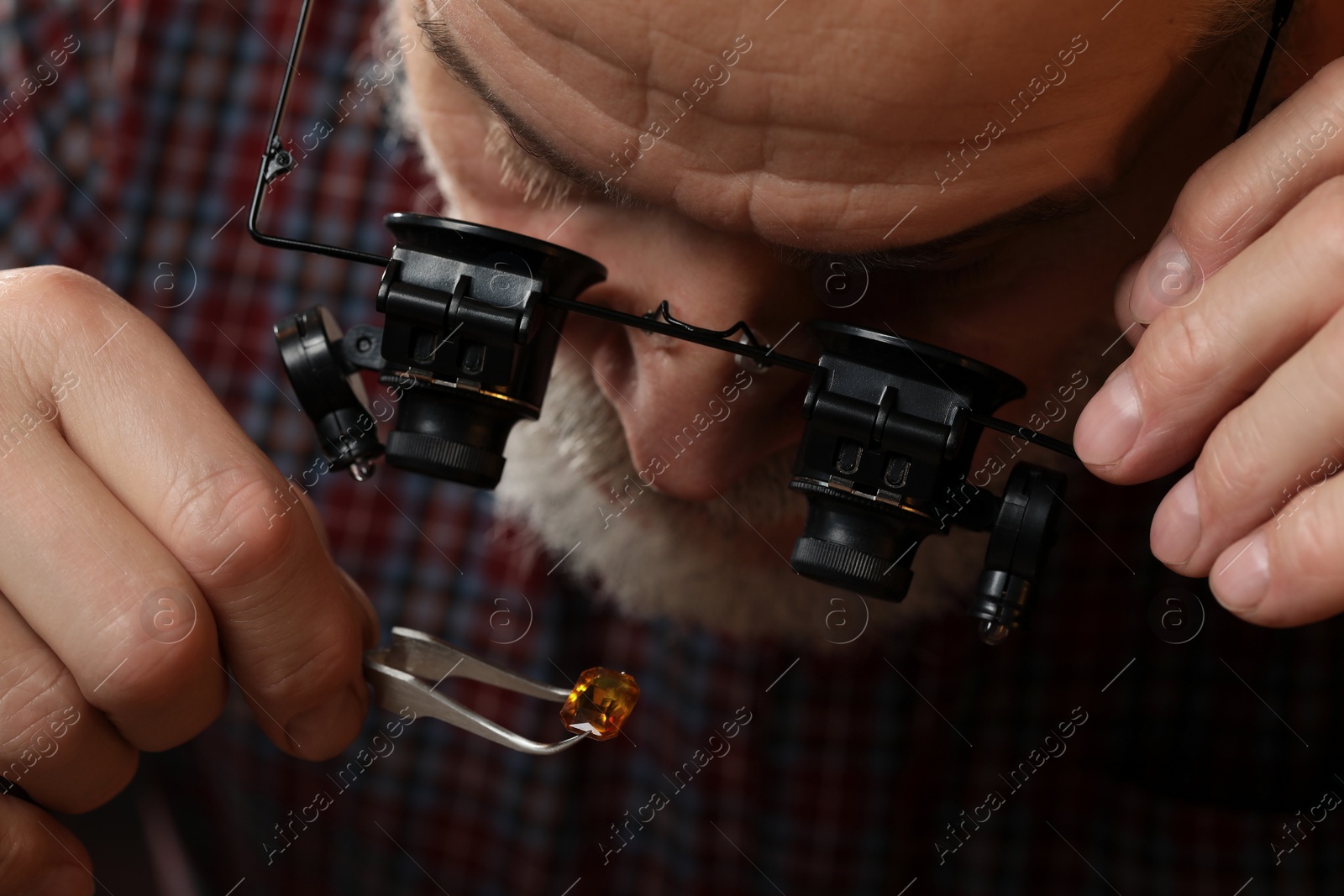 Photo of Professional jeweler working with gemstone, closeup view