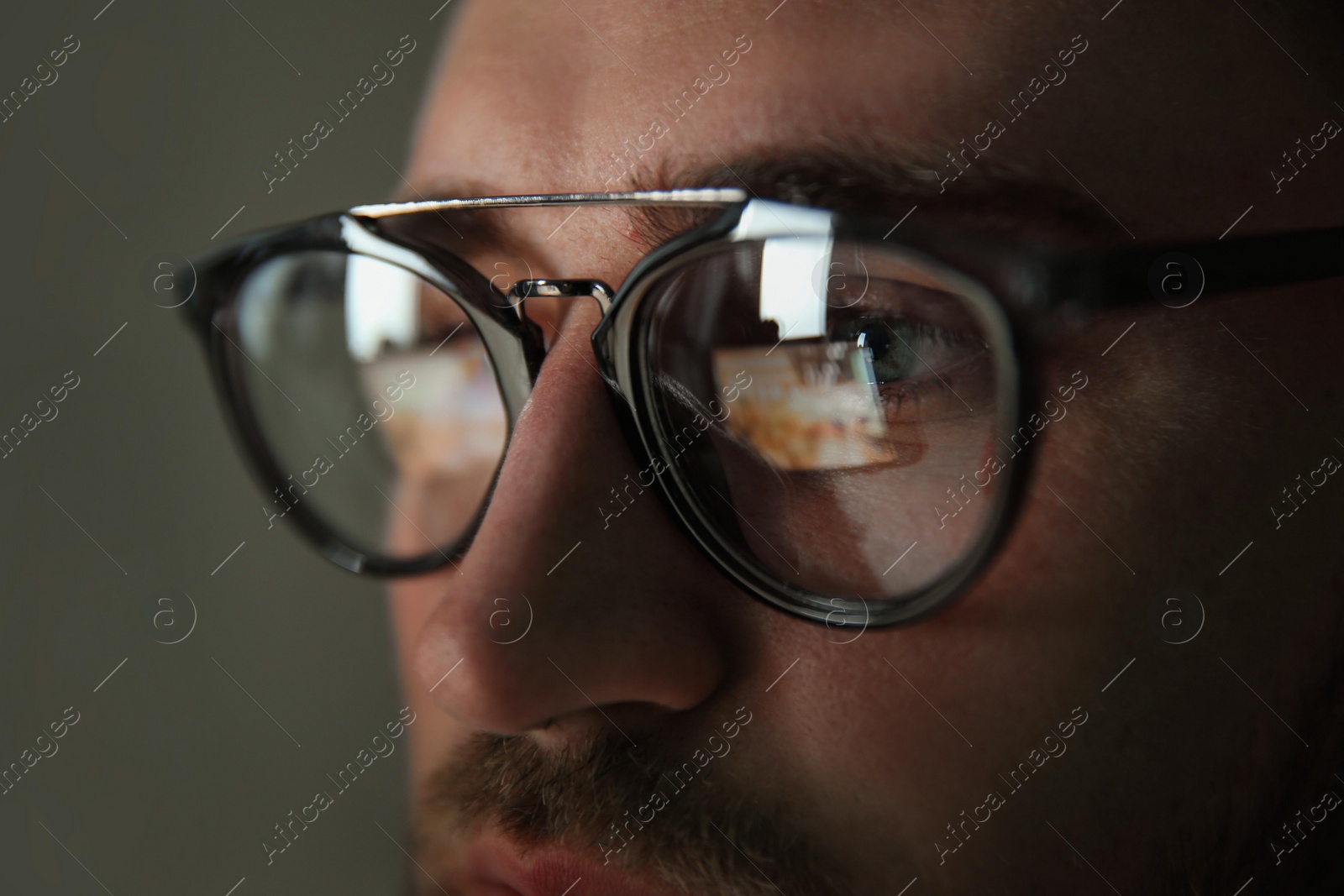 Photo of Young man wearing glasses on color background, closeup. Ophthalmology service