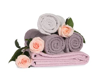 Photo of clean soft towels with flowers isolated on white