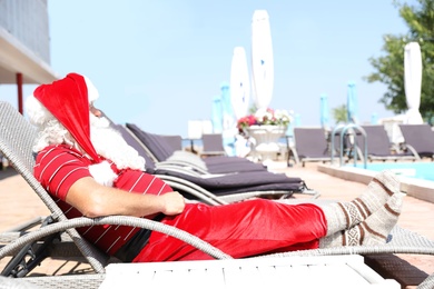 Photo of Authentic Santa Claus resting on lounge chair at resort