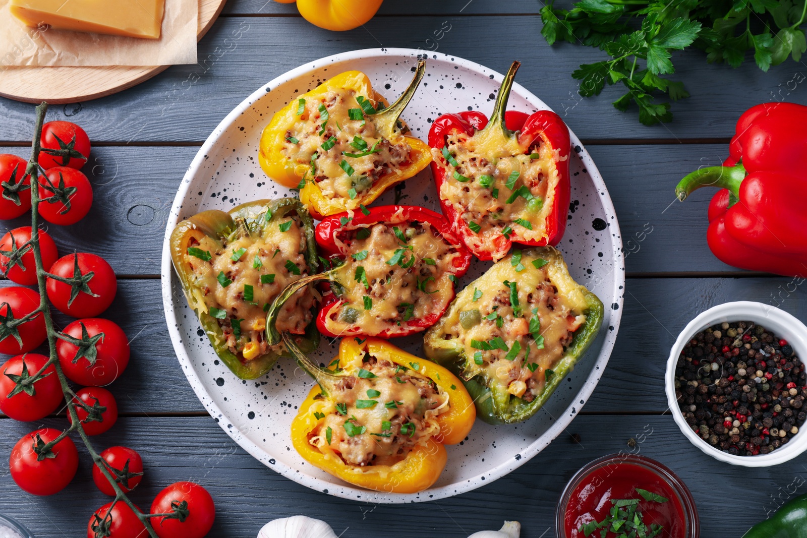 Photo of Flat lay composition with tasty stuffed bell peppers on grey wooden table