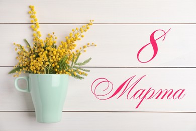 Greeting card design. Bouquet of beautiful mimosa flowers on wooden table and text 8 March written in Russian, top view