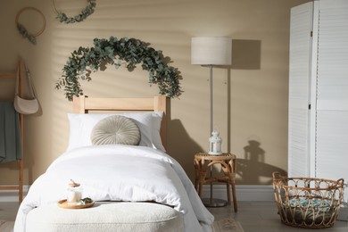 Photo of Stylish bedroom decorated with beautiful eucalyptus garland