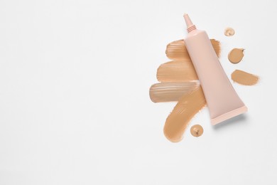 Photo of Liquid foundation and swatches on white background, top view. Space for text
