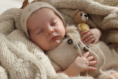 Photo of Adorable newborn baby with toy bear sleeping in basket, closeup