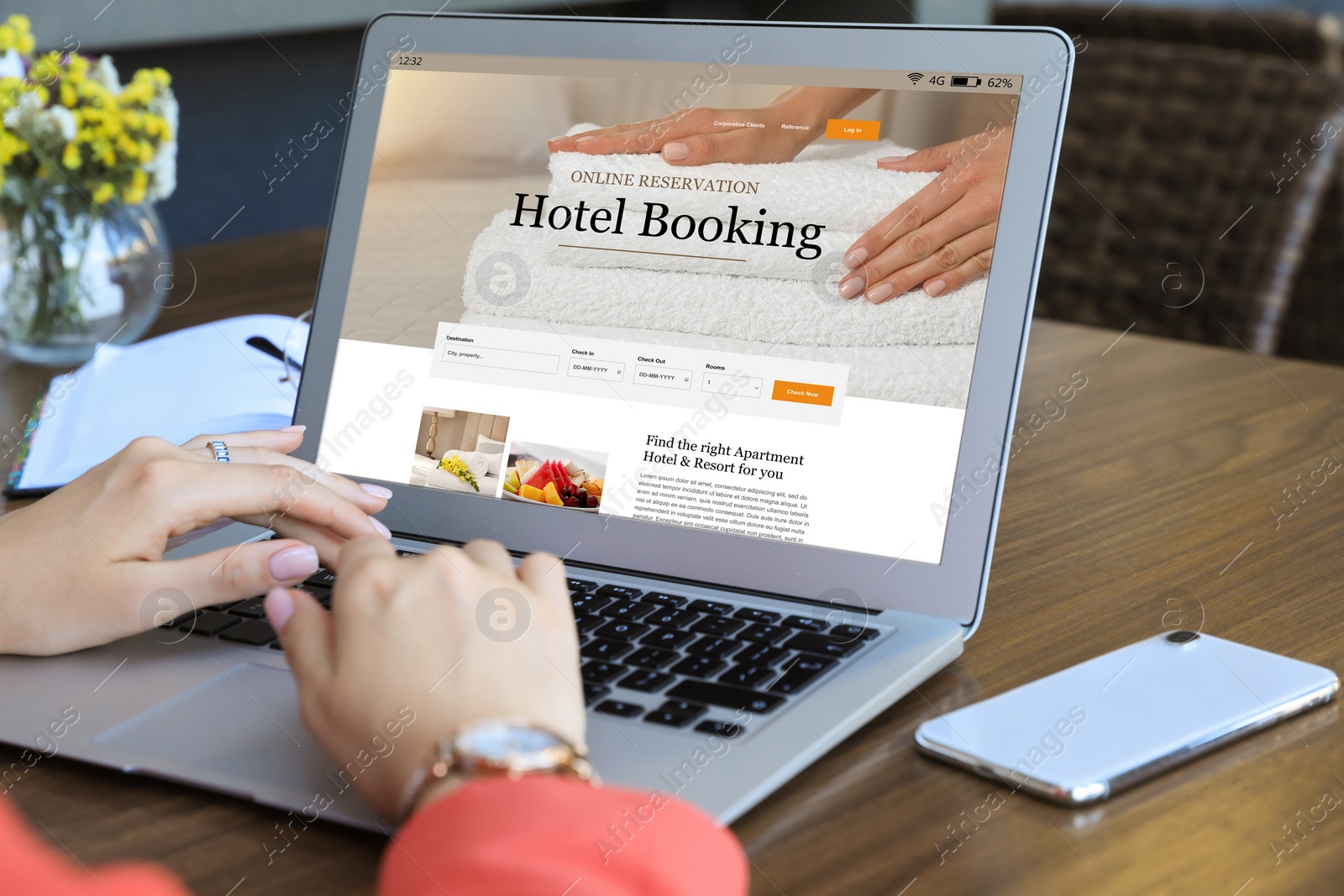 Image of Woman using laptop to book hotel at wooden table, closeup