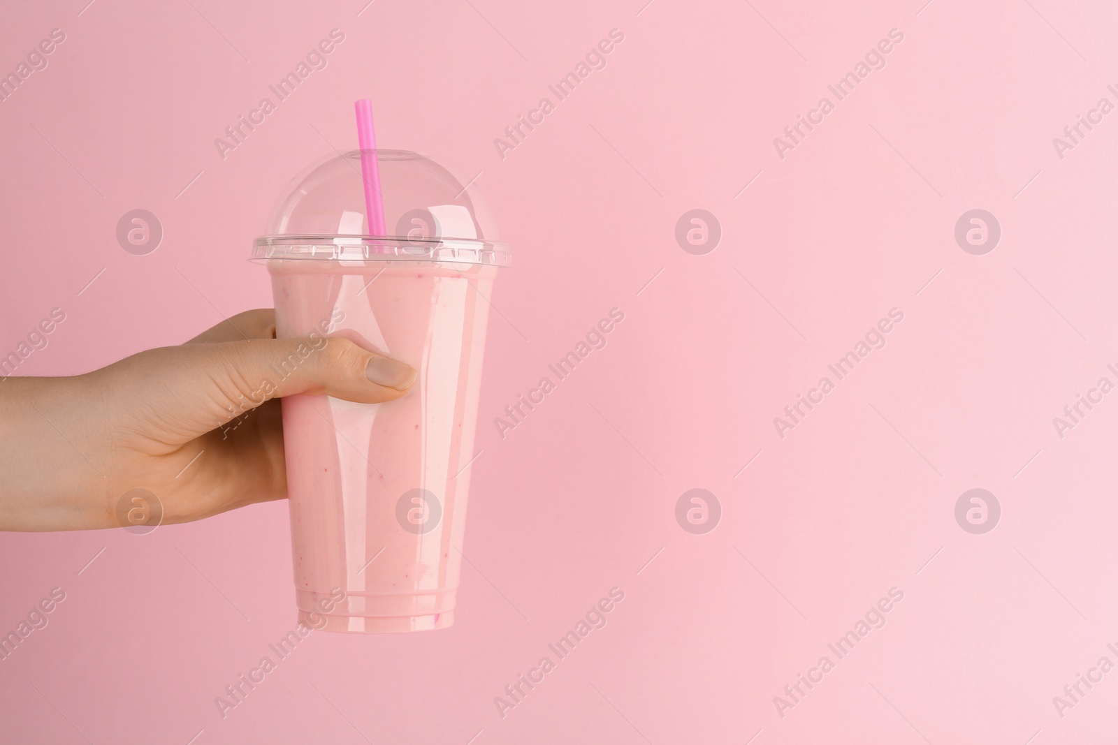 Photo of Woman with plastic cup of tasty smoothie on pink background, closeup. Space for text