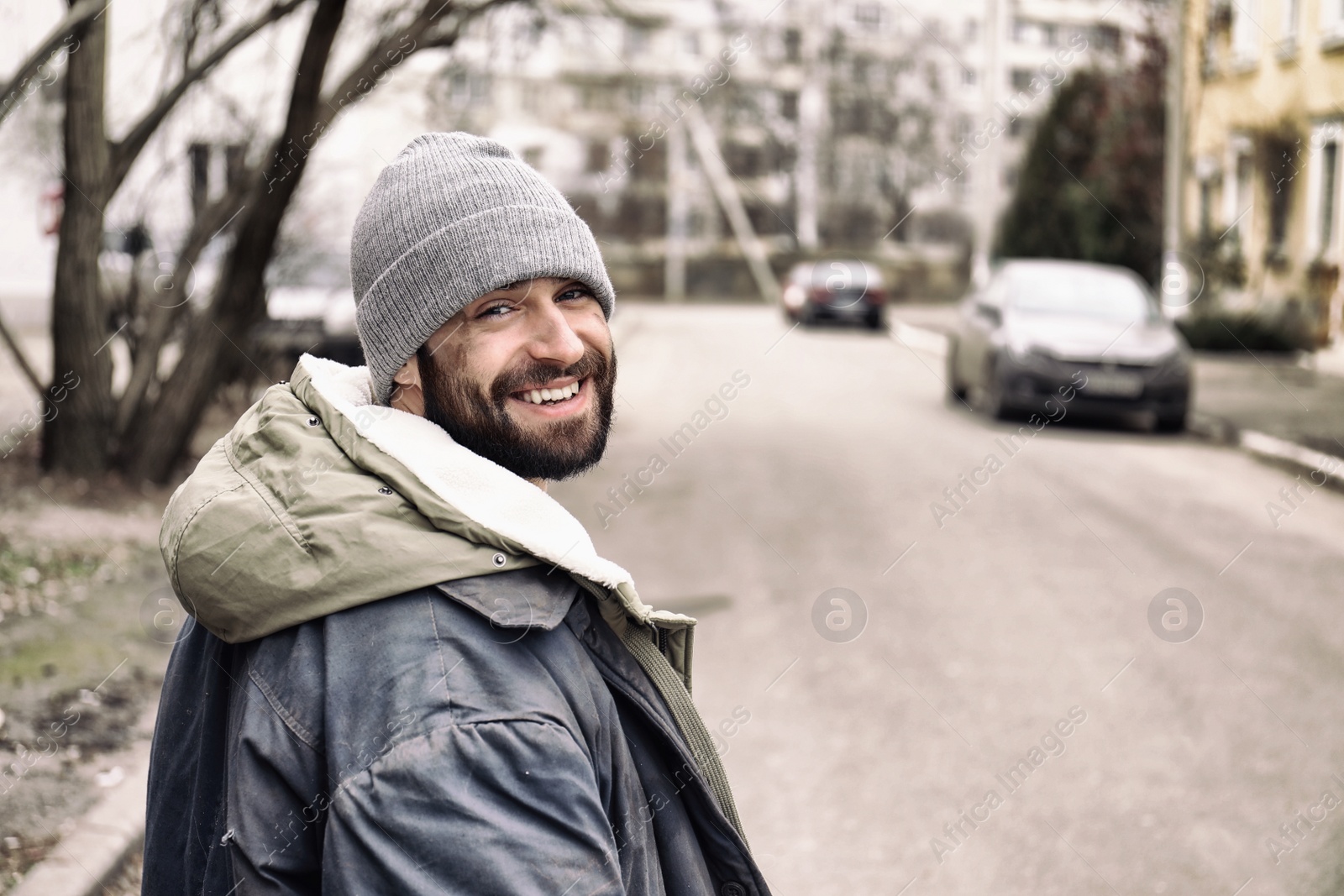 Photo of Poor homeless man standing on city street