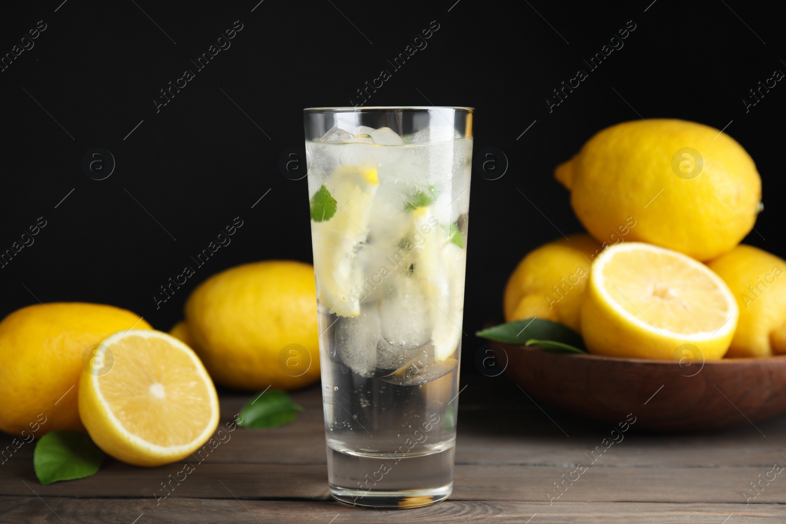 Photo of Cool freshly made lemonade and fruits on wooden table