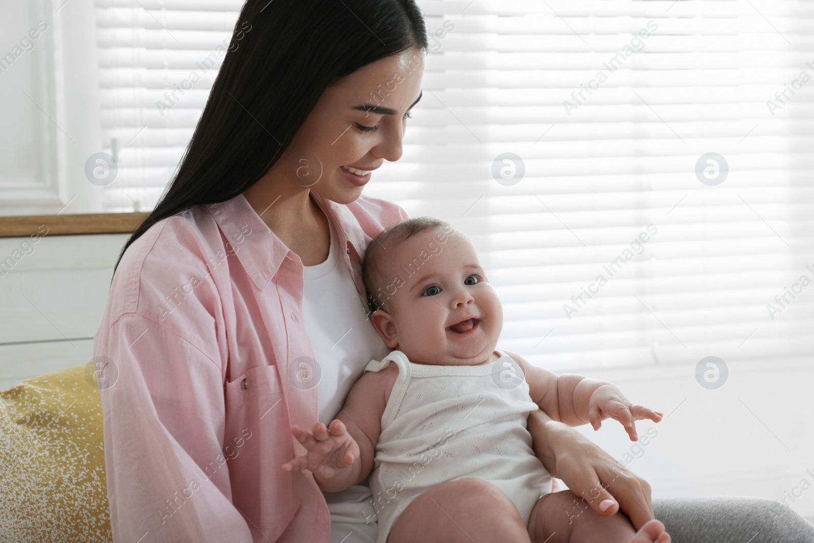 Photo of Young mother with her little baby at home