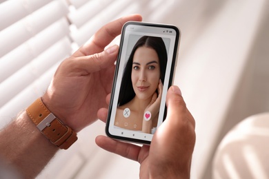 Man visiting dating site via smartphone indoors, closeup