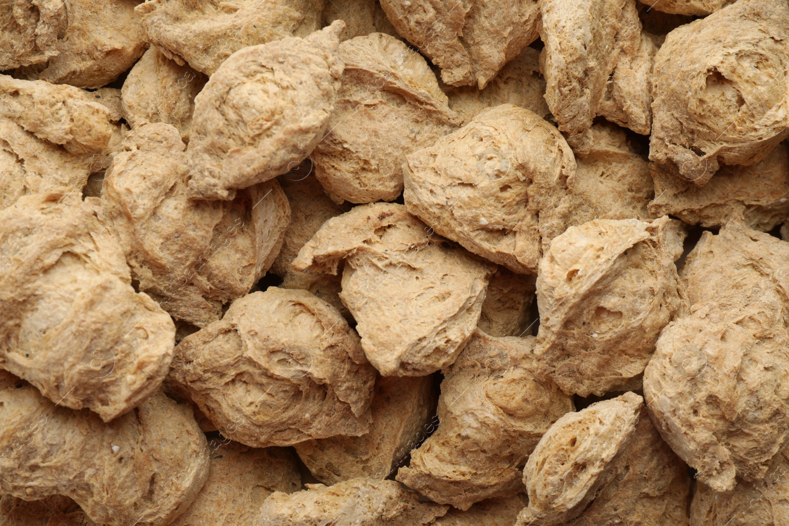 Photo of Dehydrated soy meat chunks as background, top view