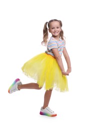Photo of Cute little girl in tutu skirt dancing on white background
