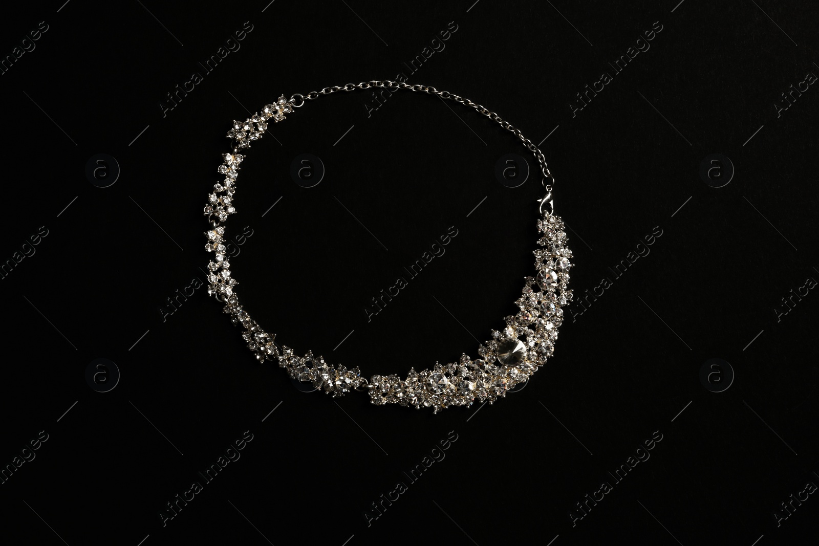 Photo of Stylish necklace with gemstones on black background, top view. Luxury jewelry