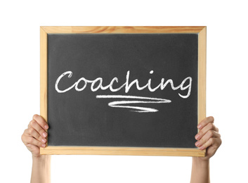 Adult learning. Woman holding blackboard with word Coaching on white background, closeup