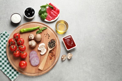 Photo of Flat lay composition with fresh pizza  ingredients on grey table. Space for text