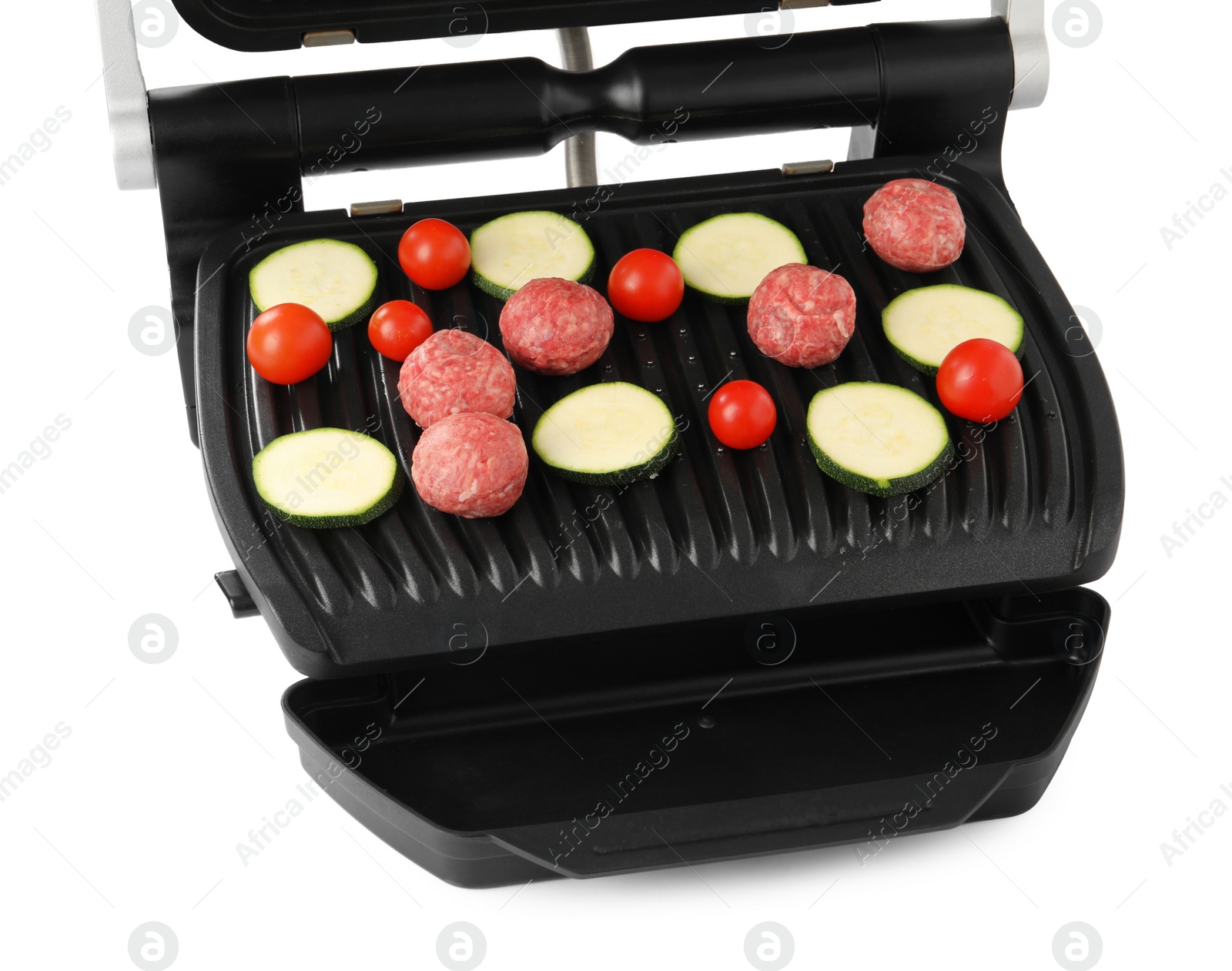 Photo of Electric grill with meat balls, zucchini and tomatoes isolated on white