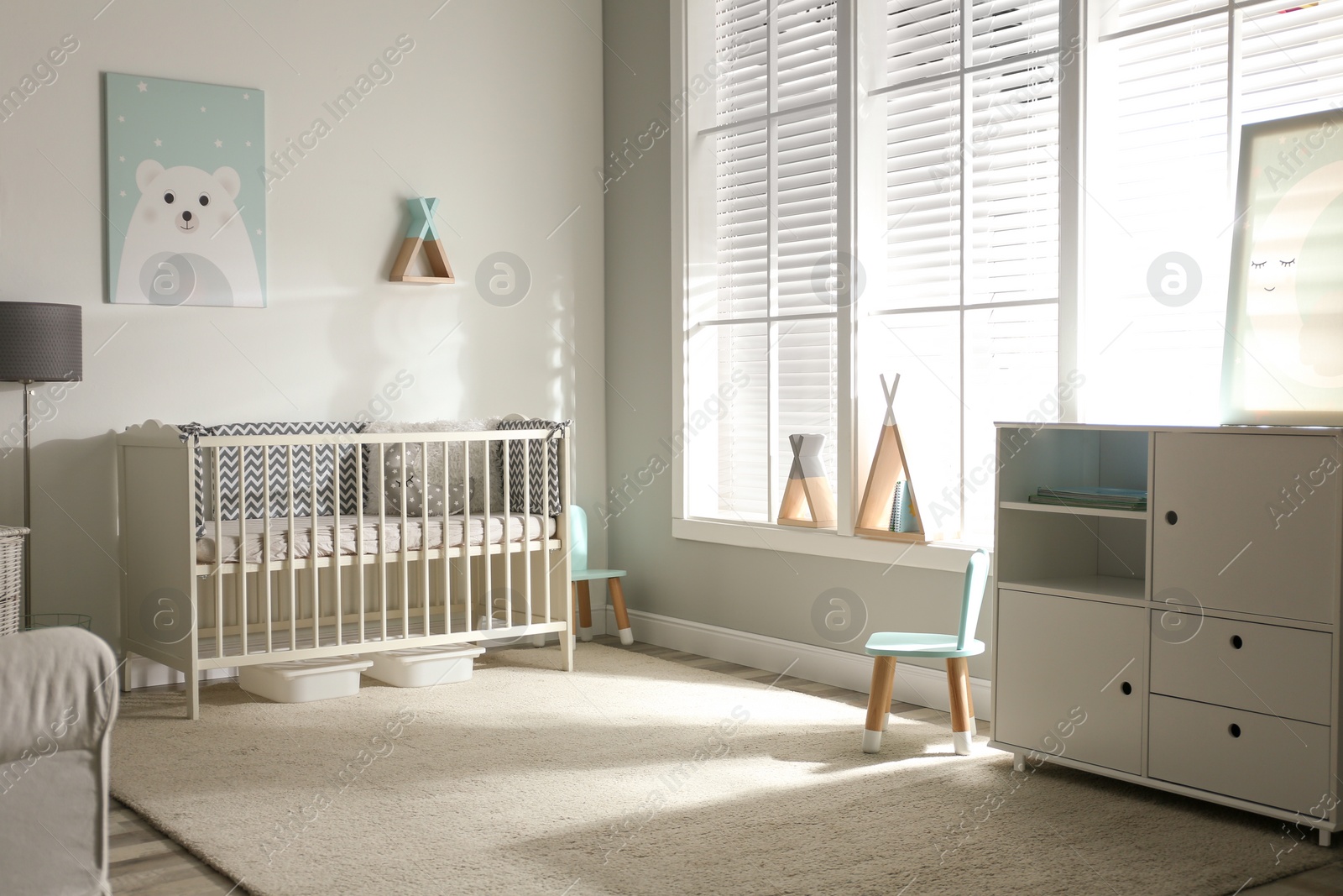 Photo of Cute baby room interior with crib and decor elements