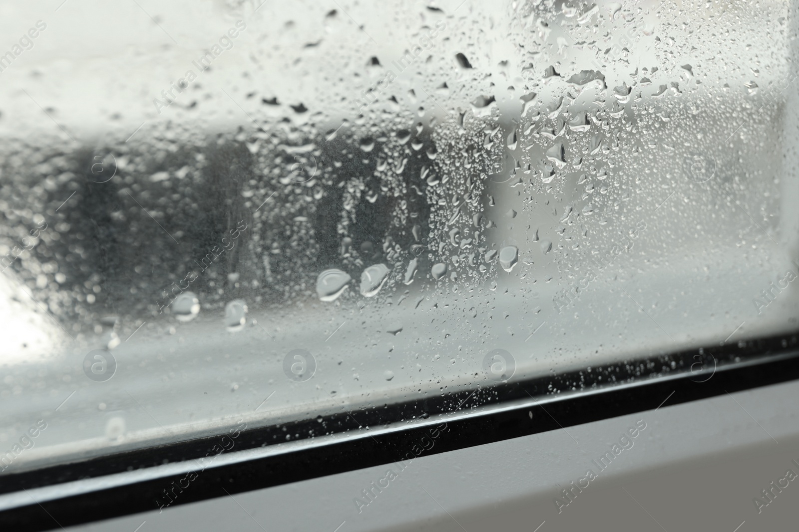 Photo of Window glass with drops of condensate indoors, closeup