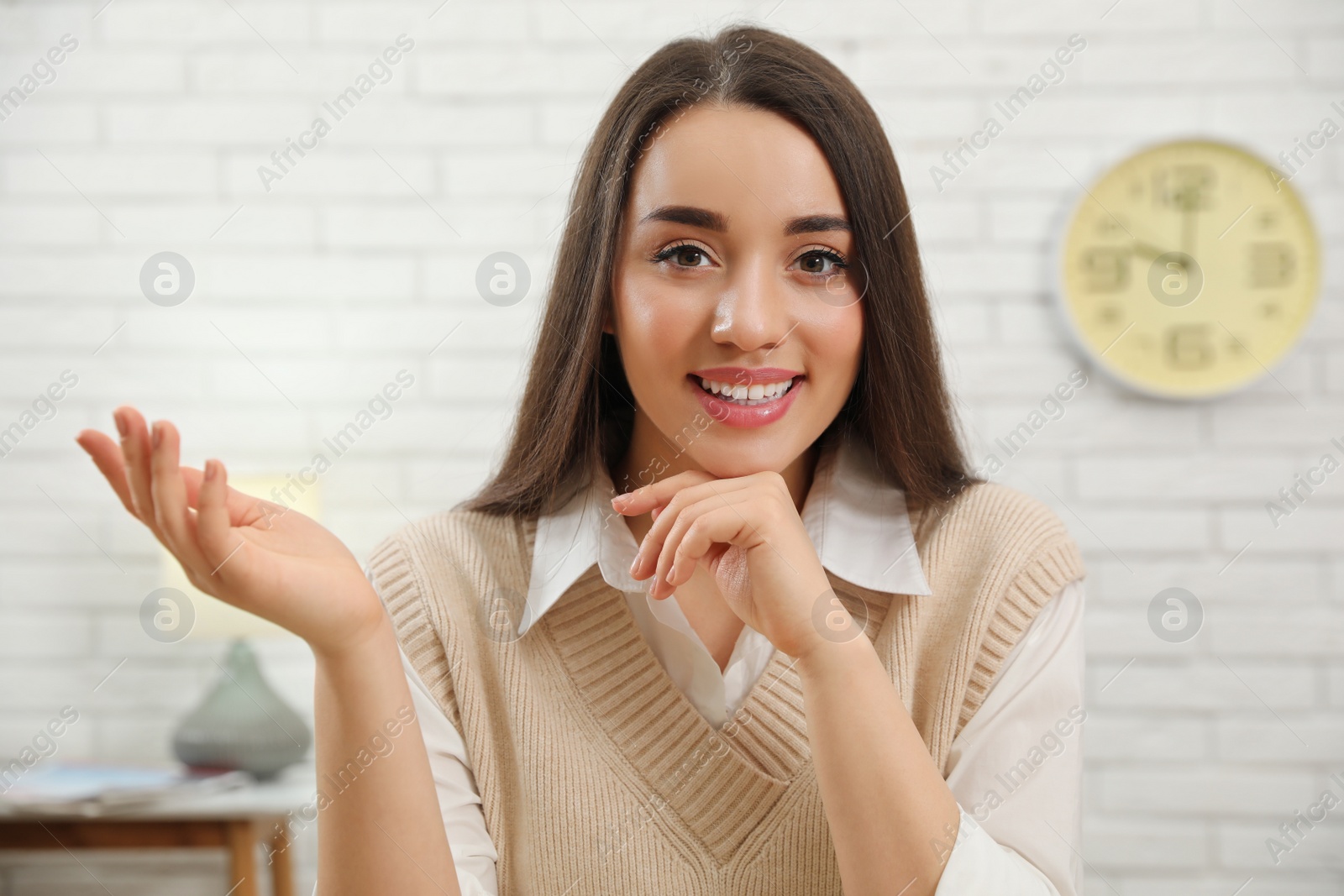 Photo of Happy young businesswoman conducting webinar in room