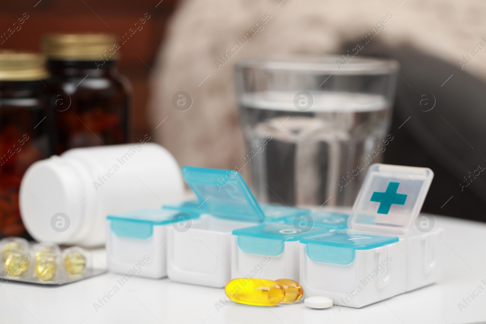 Photo of Plastic pill box with different medicaments on table