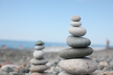 Photo of Stack of stones on beach against blurred background, closeup. Space for text