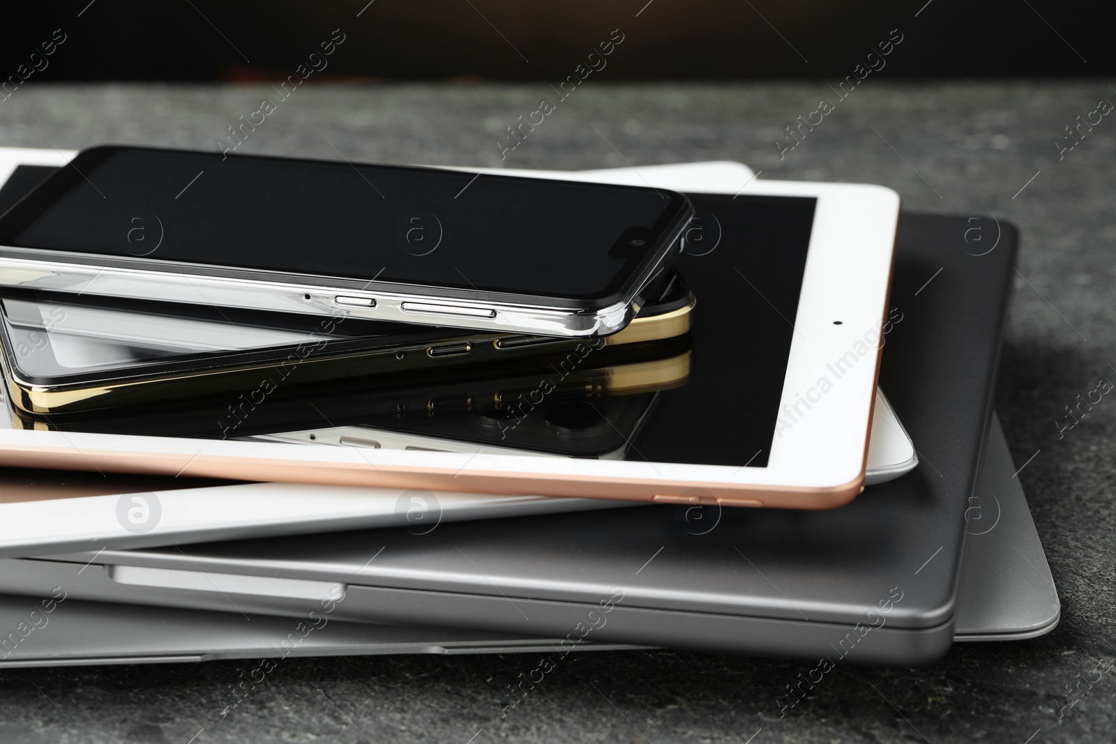 Photo of Stack of electronic devices on grey table, closeup