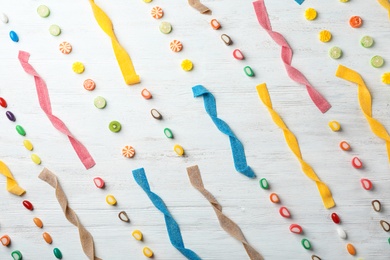 Photo of Flat lay composition with delicious colorful candies on wooden background