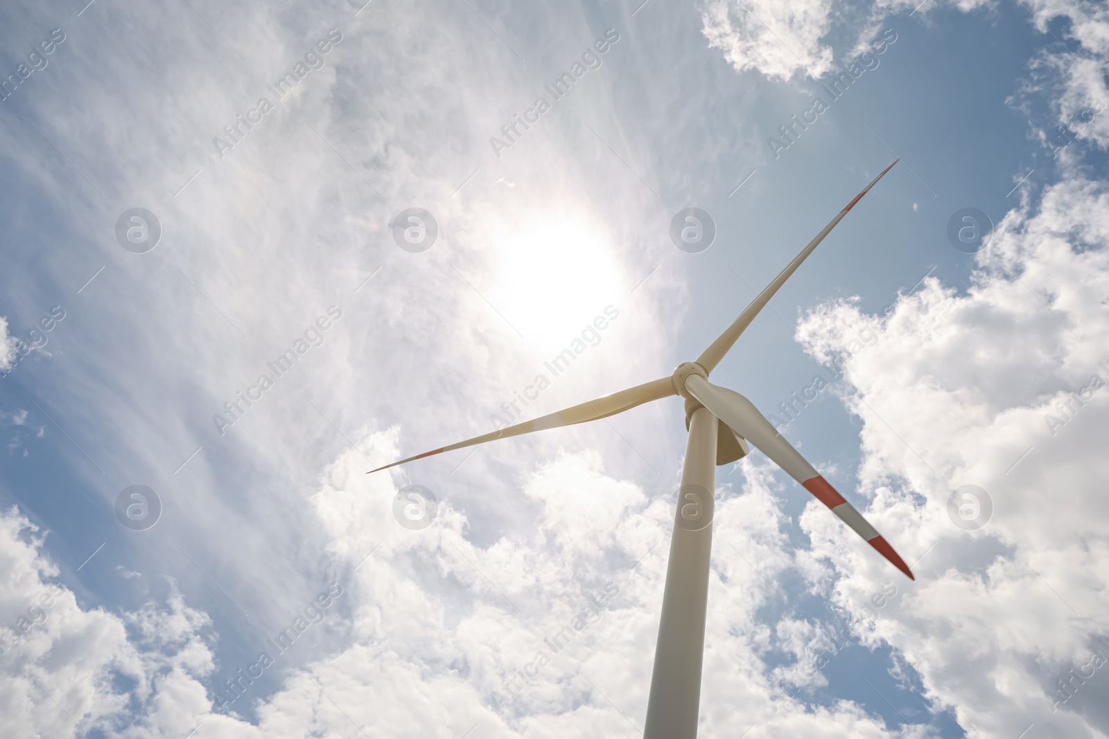 Photo of Modern wind turbine against cloudy sky, low angle view. Alternative energy source