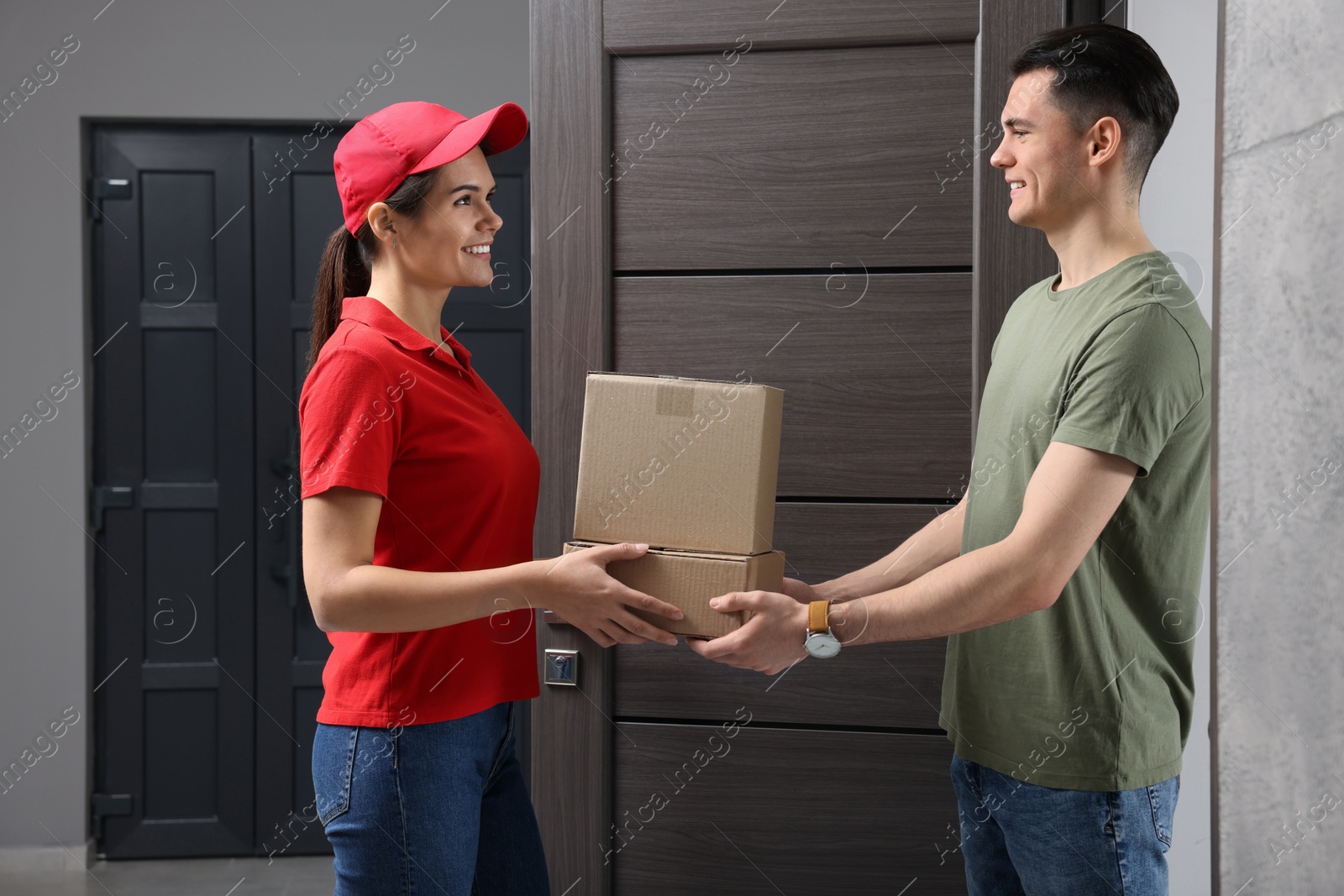 Photo of Courier giving parcel to customer at house entrance