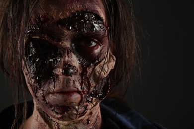 Photo of Scary zombie on dark background, closeup. Halloween monster