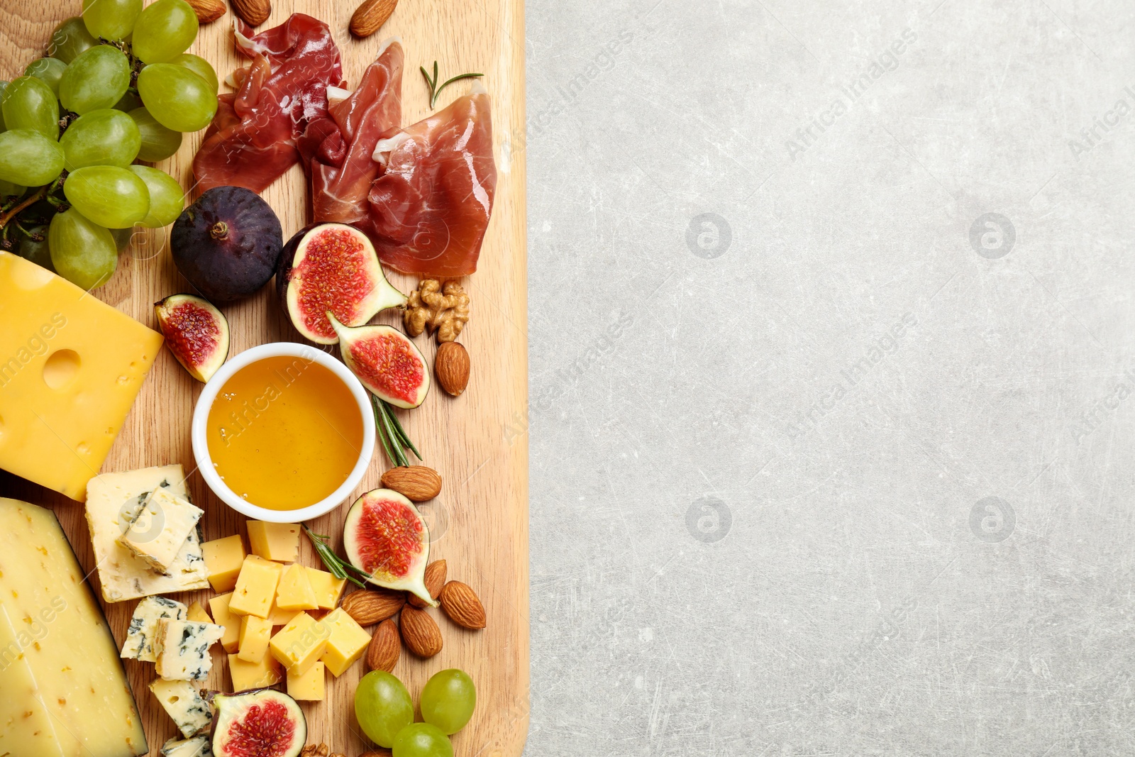 Photo of Set of different snacks with ripe figs served on light table, top view. Space for text