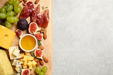 Photo of Set of different snacks with ripe figs served on light table, top view. Space for text