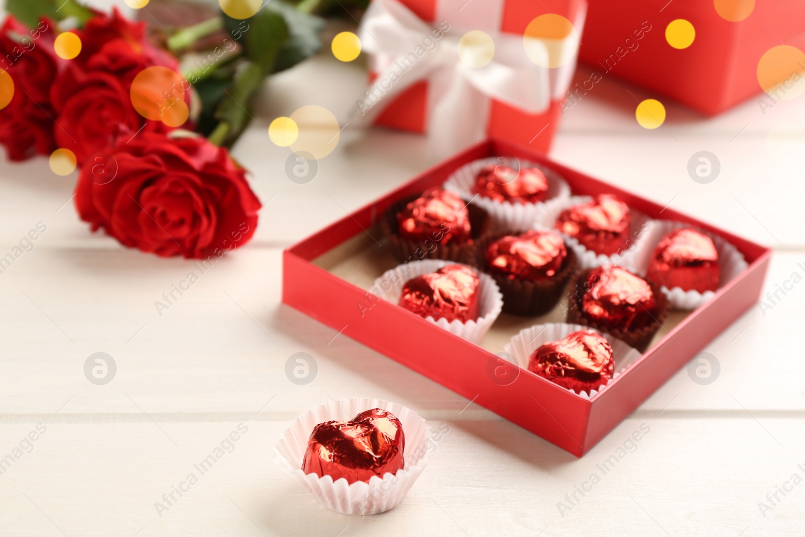 Photo of Heart shaped chocolate candies on white wooden table