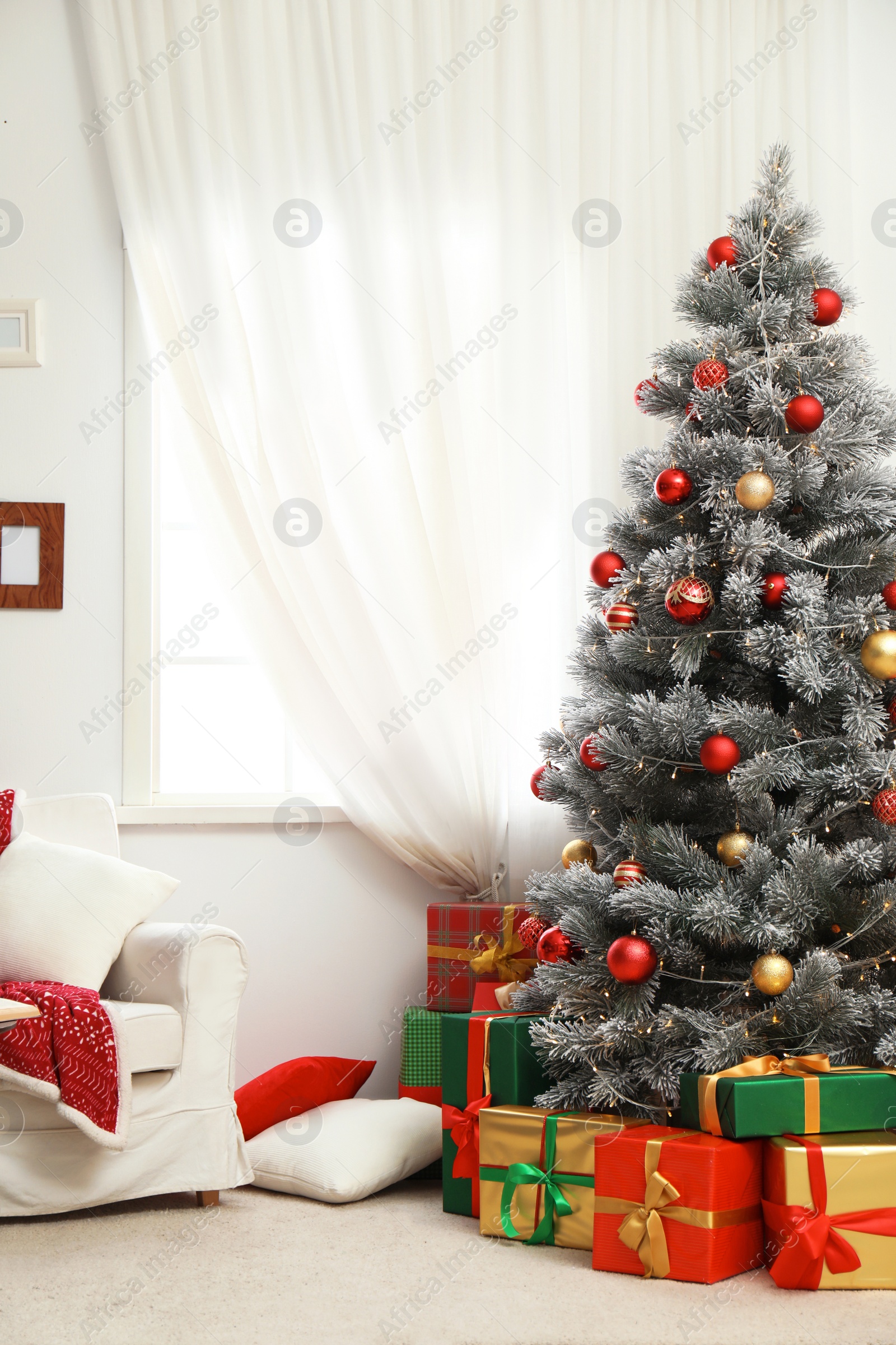 Photo of Stylish room interior with beautiful Christmas tree and gift boxes