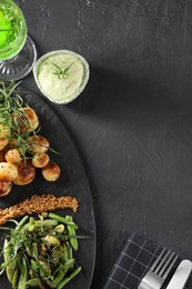 Photo of Delicious salad with tarragon, mustard and grilled potatoes served on black textured table, flat lay. Space for text