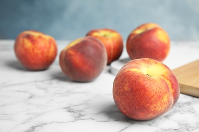 Photo of Fresh juicy peaches on white marble table